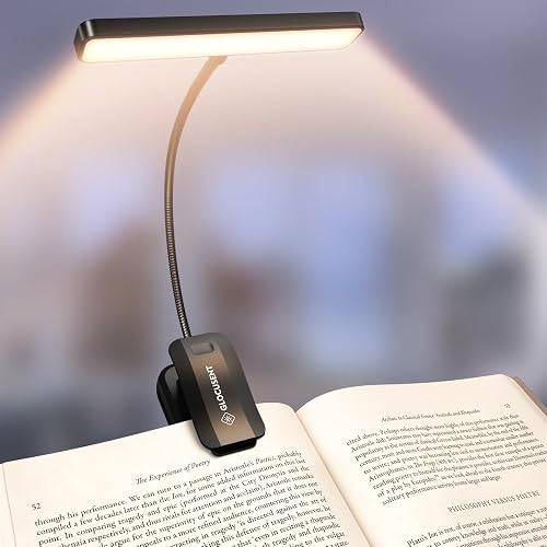 The Glocusent 26 LED book light clipped near the spine of an open hardcover, its wide head lighting both pages evenly