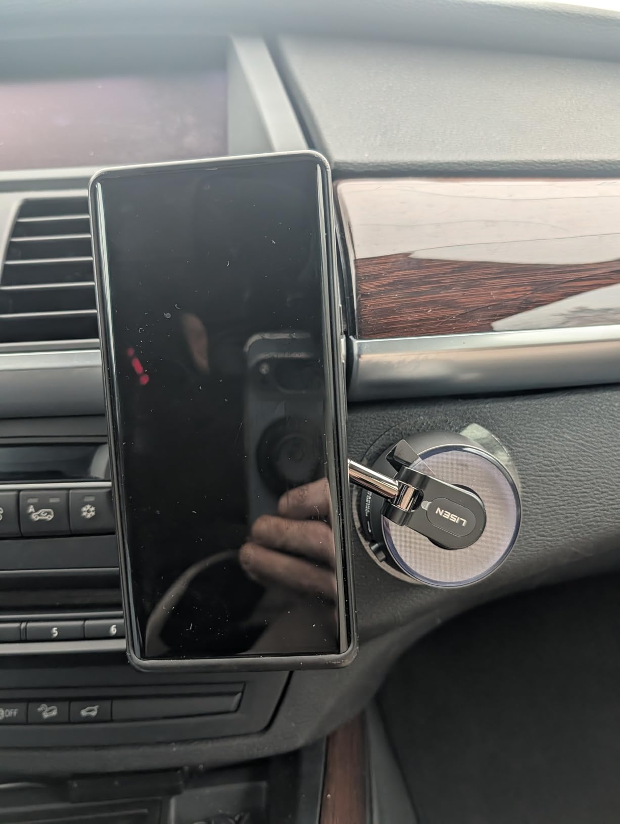 Customer photo showing the LISEN SuctionPro vacuum phone holder mounted in a car