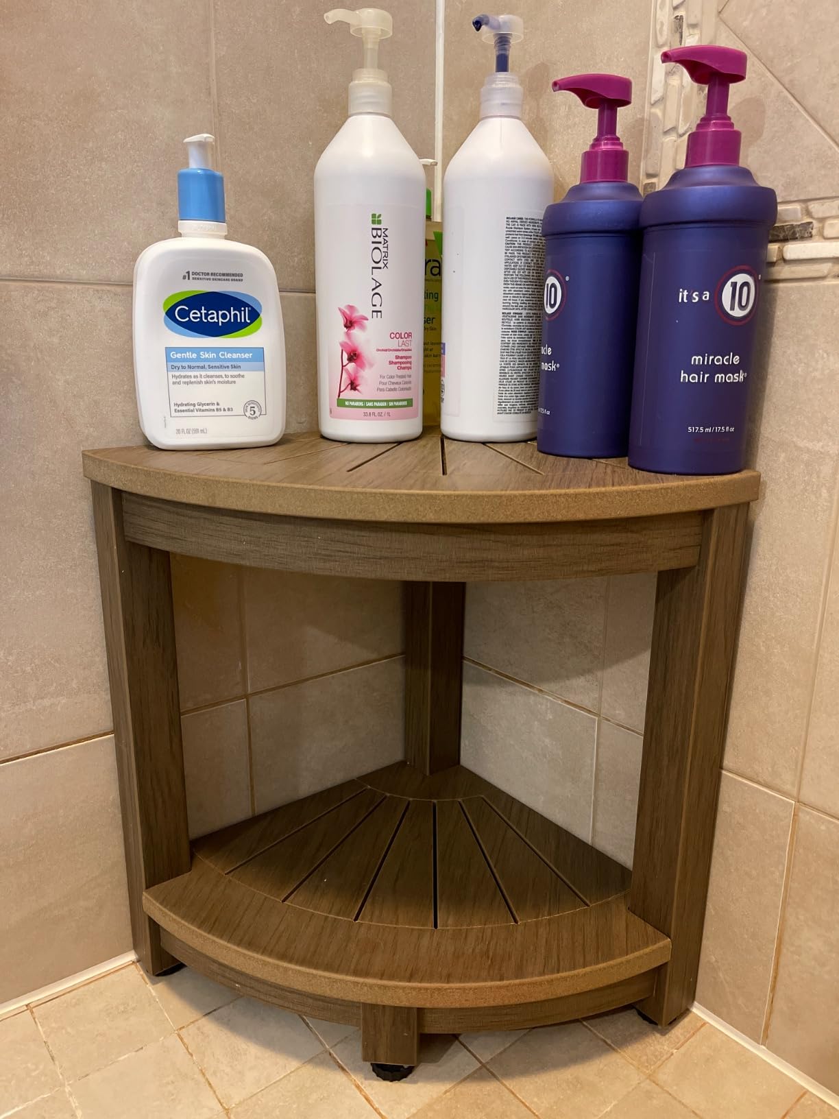 Close-up of the ROHKEX Corner Shower Stool storage shelf with bottles